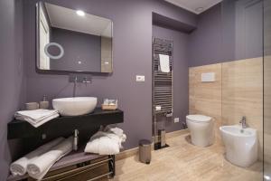 a bathroom with a sink and a toilet and a mirror at Household Settembrini in Milan