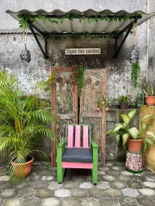 una silla sentada frente a un edificio con plantas en Judys Home - Bed and breakfast, en Retalhuleu