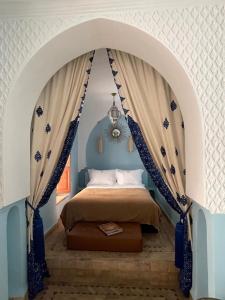 a bedroom with a bed with a canopy at Riad Ksar Al Amal in Marrakech