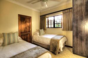 um quarto com 2 camas e uma janela em Nut Grove Manor Boutique Hotel em White River