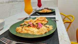 um prato verde com peixe e batatas fritas numa mesa em Status Motel - Check In Livre em Serra