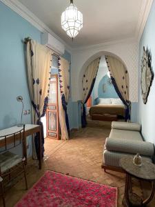 馬拉喀什的住宿－Riad Ksar Al Amal，一间卧室配有两张床和吊灯。