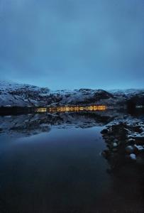 Ardlui的住宿－Bonnie Banks Lodge Ardlui，雪中灯光下的湖景之夜