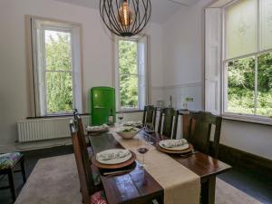 The Residence في Cleator: غرفة طعام مع طاولة وكراسي ونوافذ