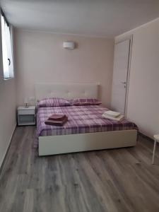 1 dormitorio con 1 cama y suelo de madera en Villetta 4 Colonne, en Nardò