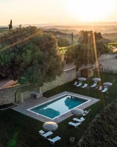 einen Luftblick auf einen Pool mit Sonnenschirmen in der Unterkunft Agriturismo Castello di Montauto in San Gimignano