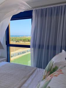 um quarto com uma cama e uma grande janela em Apartamento duplex Mediterránean view em Gandia