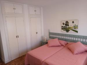 een slaapkamer met een roze bed en witte kasten bij NEW MARITIMO in Málaga