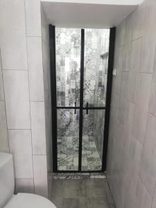 baño con aseo y ventana en Apartament Brezoi, en Brezoi