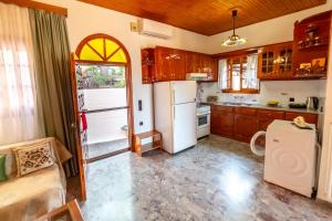 a kitchen with wooden cabinets and a white refrigerator at Traditional village house in Ágios Matthaíos +12 photos