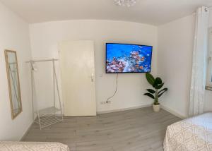 salon z telewizorem na ścianie w obiekcie Apartment Bonbon - stilvoll renoviert - Ihr zu Hause auf Zeit w mieście Kassel