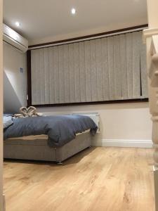 a bedroom with a bed and a large window at Studio flat in the heart of Golders Green in London