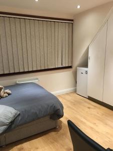 a bedroom with a bed and a large window at Studio flat in the heart of Golders Green in London