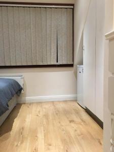 an empty room with a bed and a window at Studio flat in the heart of Golders Green in London