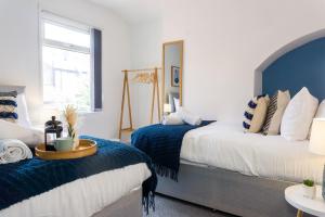 a bedroom with two beds with blue and white at Air Host and Stay - Conningsby House - Beautiful 6 bedroom sleeps 14 minutes to LFC in Liverpool