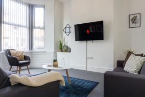 sala de estar con sofá y TV en la pared en Air Host and Stay - Conningsby House - Beautiful 6 bedroom sleeps 14 minutes to LFC, en Liverpool