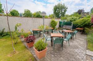 un patio con mesas, sillas y plantas en Radfahrerherberge Krems, en Krems an der Donau