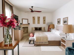 1 dormitorio con 1 cama y un jarrón de flores en Canne Bianche Lifestyle Hotel en Torre Canne