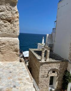 widok na budynek z oceanem w tle w obiekcie Dimora La Terrazza w mieście Polignano a Mare
