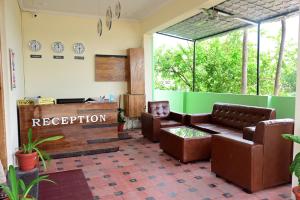 a waiting room with leather chairs and a reception desk at Hotel Stay Shine in Mysore