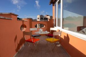 eine Terrasse mit einem Tisch und Stühlen auf dem Balkon in der Unterkunft Palazzo Belli Roma in Rom