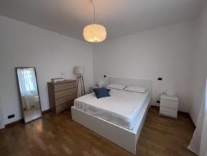 um quarto branco com uma cama e um espelho em San Martino Apartment - Moniga del Garda em Moniga