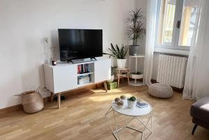 uma sala de estar com uma televisão de ecrã plano num armário branco em San Martino Apartment - Moniga del Garda em Moniga