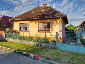 a yellow house with a fence in front of it at Zadora Haus in Săcele