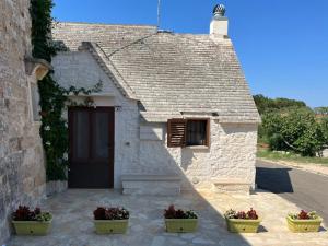 un bâtiment avec deux plantes en pot devant lui dans l'établissement lacasadikarma, à Locorotondo