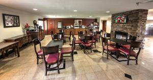 a restaurant with tables and chairs and a fireplace at Red Roof Inn PLUS+ Henderson in Henderson