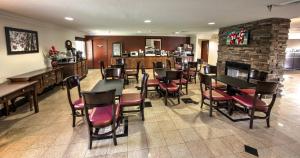 un restaurante con mesas y sillas y una chimenea en Red Roof Inn PLUS+ Henderson, en Henderson