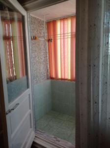 uma casa de banho com um chuveiro e uma porta de vidro em Apartament Anastasia.Plaja Modern em Constança