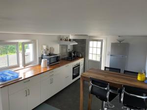 a kitchen with white cabinets and a wooden table at Proximité Biarritz - Arcangues in Arcangues