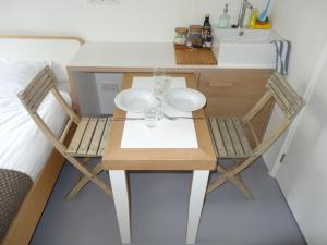 mesa pequeña con 2 sillas y lavamanos en The Amsterdam Houseboat Family - de Pijp, en Ámsterdam