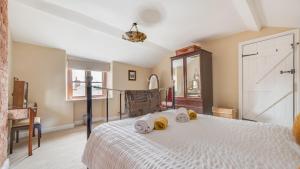 um quarto com uma cama branca e toalhas em Bobbin Cottage em Belper