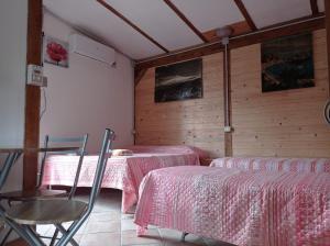 カスティリオーネ・ディ・シチーリアにあるChalet Don Boscoのベッド2台と椅子が備わる客室です。