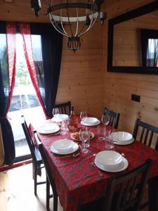 uma mesa de jantar com pratos e copos de vinho em Domek na grapie em Gilowice