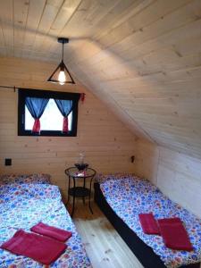 a bedroom with two beds and a table in a attic at Domek na grapie in Gilowice