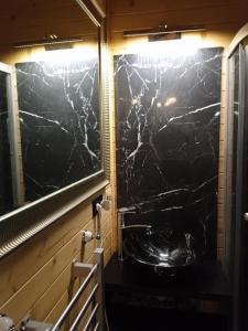 a bathroom with a black marble wall at Domek na grapie in Gilowice