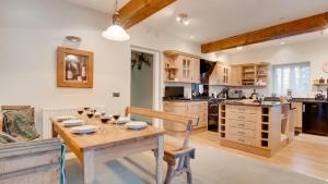 uma cozinha com uma mesa de madeira com copos em Frogmore Cottage em Two Dales