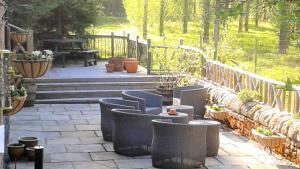 a patio with chairs and a table and a bench at Frogmore Cottage in Two Dales