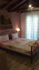 een groot bed in een slaapkamer met een raam bij House Roula in Neos Marmaras