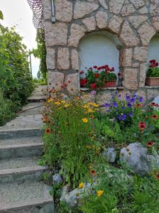 un jardín con flores en una pared de piedra en Kerti lak, en Mór