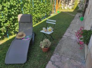 una parrilla, una mesa y una silla en un patio en Kerti lak, en Mór
