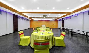un salón de banquetes con mesas verdes y sillas amarillas en Itsy By Treebo - Anjali Mahal 500 Mtrs From Mathura Railway Station en Mathura