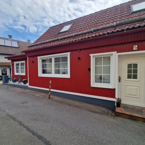 czerwony dom z dwoma oknami i białymi drzwiami w obiekcie Ferienhaus Aaron inkl Bettwäsche Handtücher Endreinigung w mieście Hahnenklee-Bockswiese