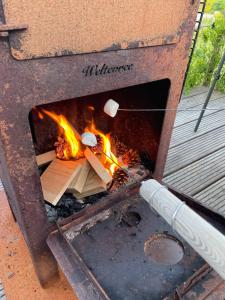 um fogo dentro de um forno de pizza com fogo em WAD NOU Terschelling heerlijk duurzaam chalet! em Midsland