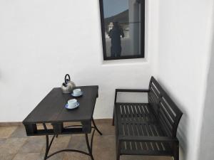 a black table and a bench and a table and chair at Finca La Tabaiba Apartamento alto in Máguez