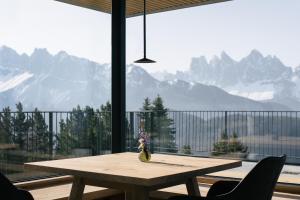 drewniany stół przed dużym oknem z górami w obiekcie anders mountain suites 2 w mieście Brixen +31 zdjęć