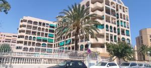 a palm tree in front of a building at vacaciones en pineda con 2 piscinas, playa a 5 min in La Pineda